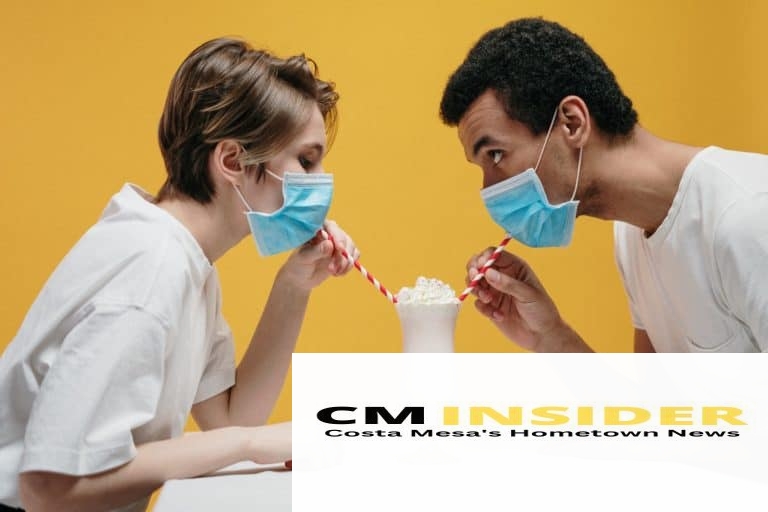 couple wearing face mask drinking milkshake