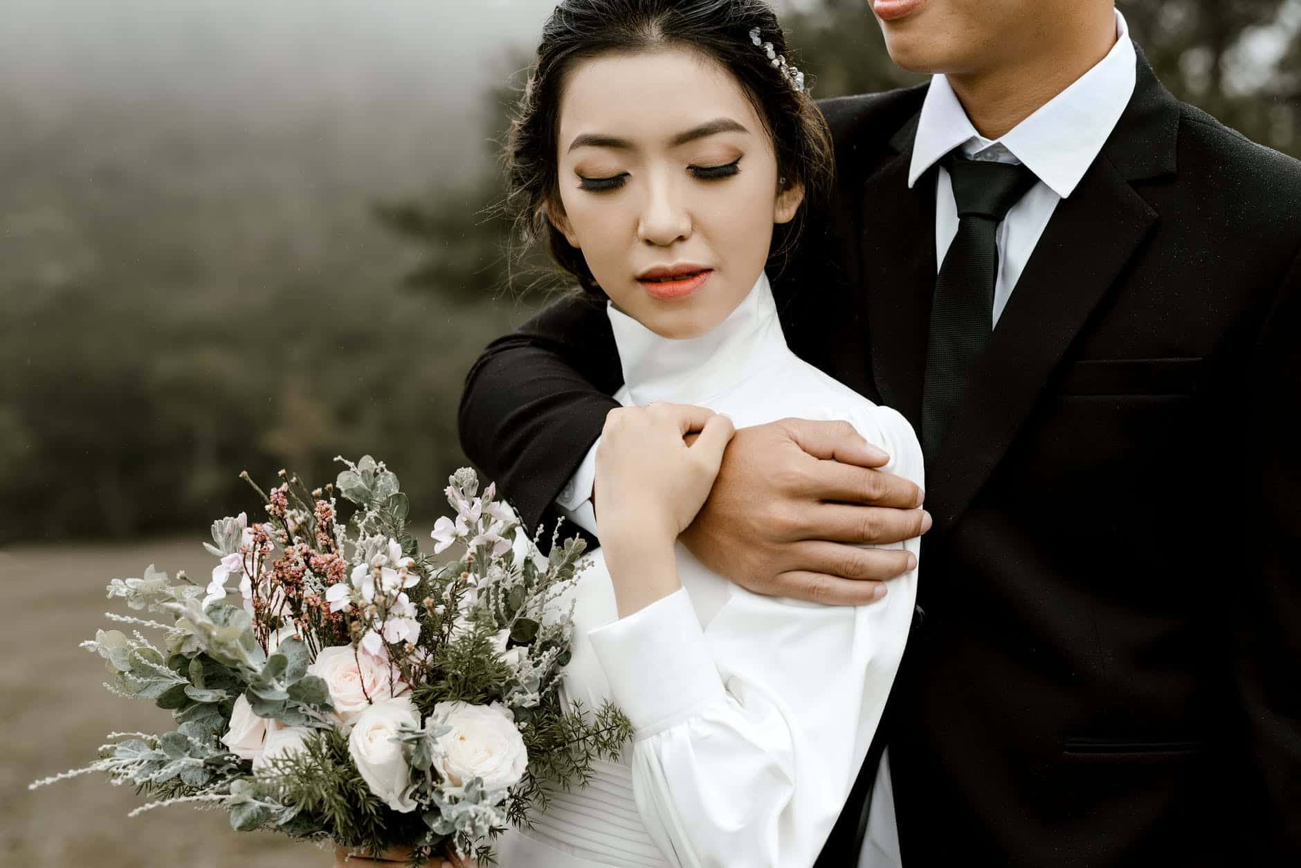 woman wearing white long sleeved dress beside man