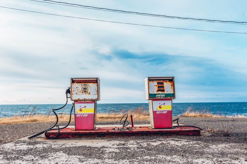 white and pink gasoline station near ocean