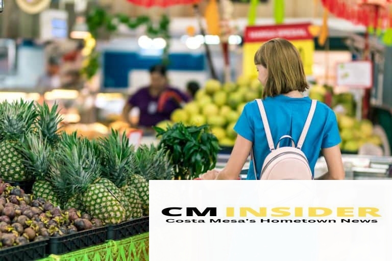 woman standing beside pineapple fruits